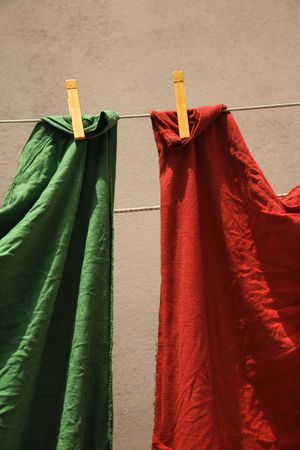 Red and green fabric hanging on clothesline in Lisbon, Portugal.の写真素材