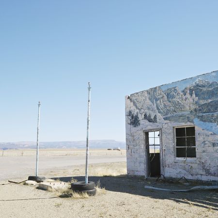 Building in barren desert landscape with winter scene mural painted on side.の写真素材