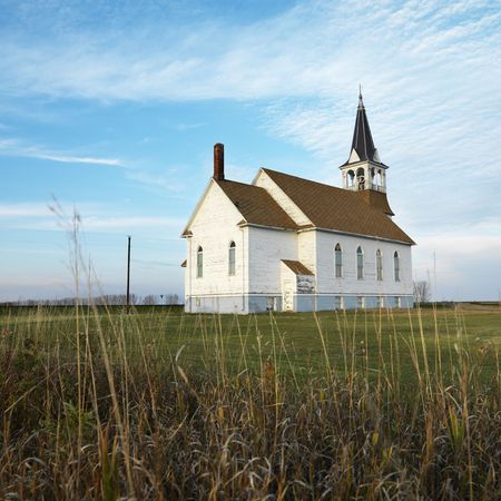 Small rural church in field with chipped wood siding.の写真素材
