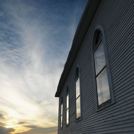 Sunset behind side view of building with arched windows.の写真素材