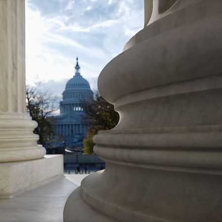 View of Capitol building in distance from behind columns of the Supreme Court building in Washington DC.の写真素材