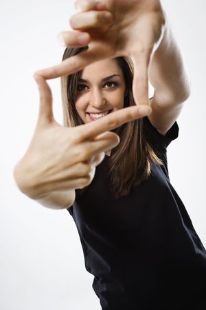 Portrait of young Caucasian female smiling with hands in foreground.の写真素材