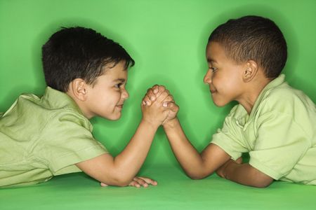 Hispanic and African American male child arm wrestling.の写真素材