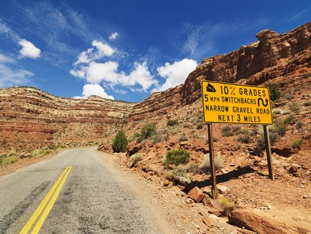 Road sign warning steep grade through rocky Utah landscape.の写真素材
