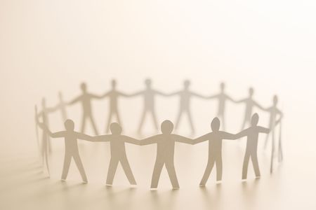 Cutout paper people standing in circle holding hands.の写真素材