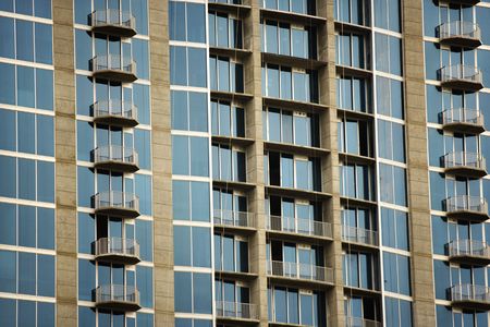 Exterior of high rise building with mirrored windows and balconies.