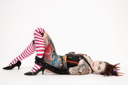 Adult caucasian woman with tattoos lying on floor.の写真素材