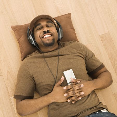 African-American man wearing headphones and listening to mp3 player