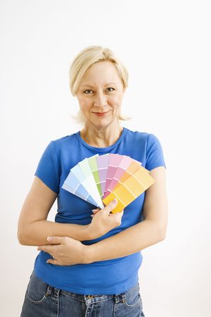 Portrait of smiling adult blonde woman holding paint swatches.の写真素材