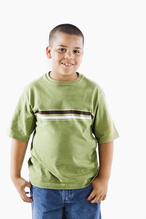 Young latino boy standing smiling.