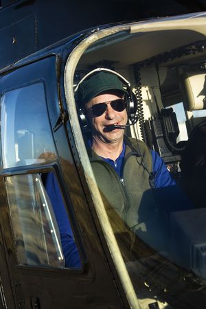 Portrait of helicopter pilot sitting in cockpit looking at viewer.の写真素材