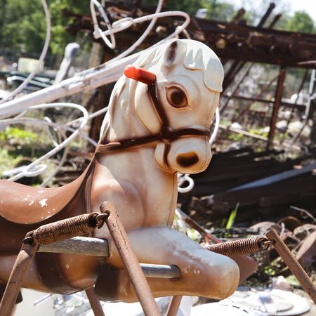 Old abandoned playground toy horse in junkyard.の写真素材