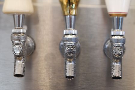 Three beer tap spouts with condensation showing on the openings. Horizontal shot.の写真素材