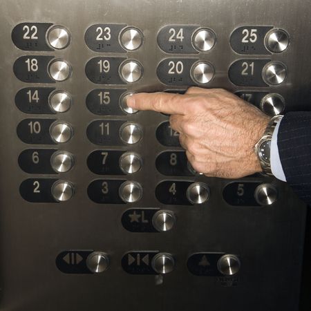 Caucasian man's hand pushes the elevator button to the fifteenth floor. Square shot.