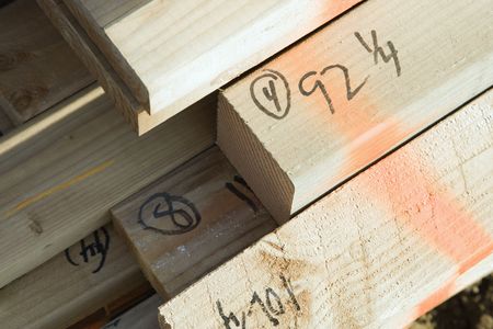 Closeup of the ends of building timber. Their lengths have been written in marker. Horizontal shot.の写真素材