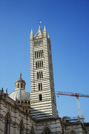 Low angle view of the Cathedral of Siena, against blue sky, in Siena, Italy. Vertical shot.の写真素材