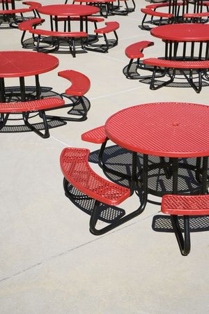 Red metal circular cafeteria tables on an outdoor patio. Vertical shot.の写真素材
