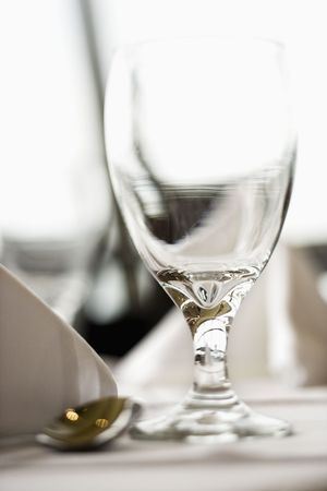Selective focus close-up of an empty water glass on a table. Vertical shot.の写真素材