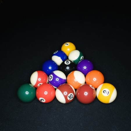 Pool tables arranged in triangle on pool table.
