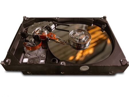 The old IDE hard disk internal components with a beautiful shiny magnetic disk.