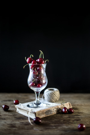 Sweet cherry in a glass on a black backgroundの写真素材