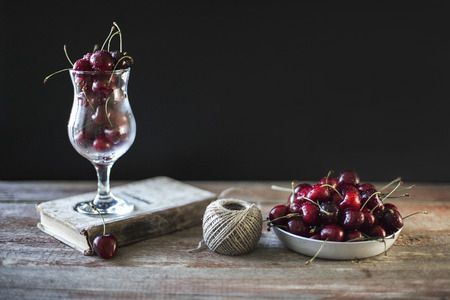 Cherries on a plate on a wooden backgroundの写真素材