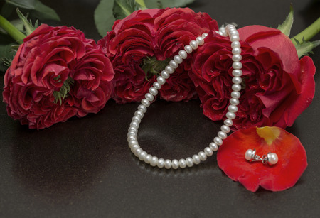 Red roses and pearls closeup