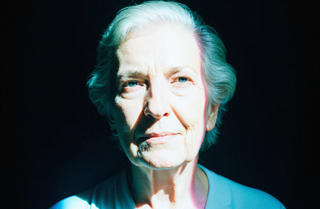 Portrait of an elderly woman on a black background in the Studioの素材