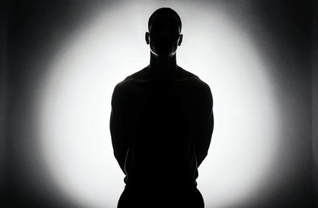 Silhouette of a man in a dark room with a spotlightの素材