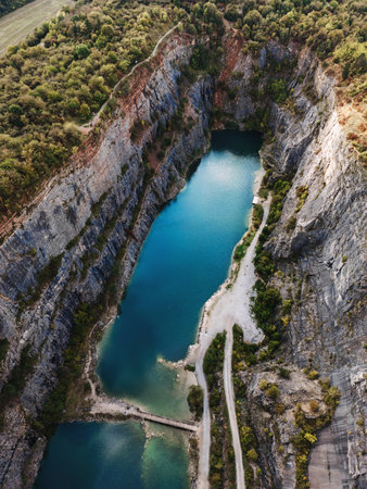 Aerial view of dramatic rocky canyon with turquoise water and lush green forest