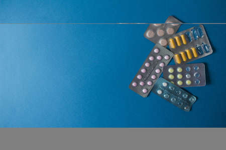 Flat lay of different blisters on blue gradient background. High quality photoの写真素材