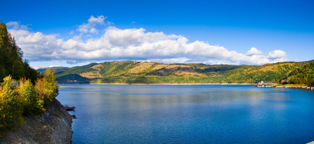 Panorama view over Izvorul Muntelui lake and dam with autumn scenery and beautiful blue skyの写真素材