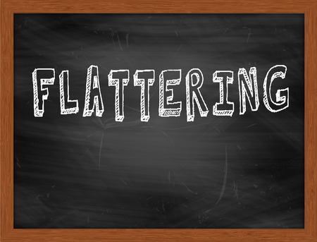 FLATTERING  hand writing text on black chalkboardの写真素材