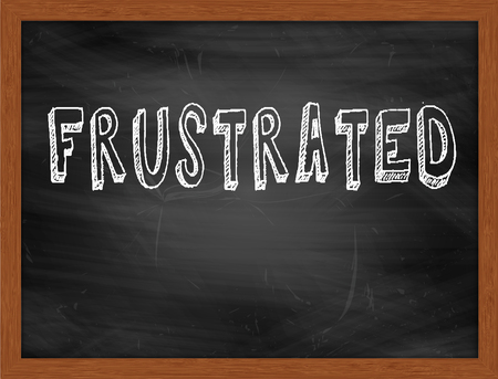 FRUSTRATED  hand writing text on black chalkboardの写真素材