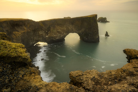 Dyrholaey arch rock formation in Iceland, near Vik, located next to black sand beach, at sunriseの写真素材