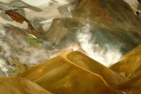 Hiker on a trail at Kerlingarfjoll in Icelandic Highlands, boiling steam from geothermal activity, snowの写真素材