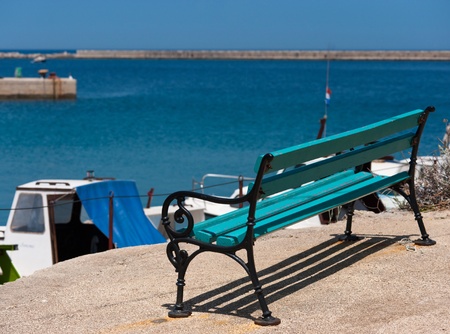 Empty Bench in front of a small mediterranean haven in croatiaの写真素材