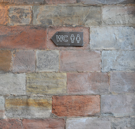 Sign to a public toilet at ancient brick wallの写真素材