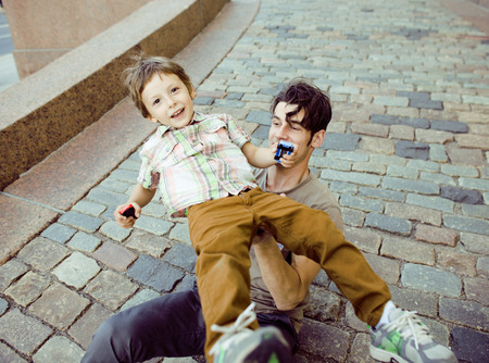 little son with father in city hagging and smiling outsideの写真素材