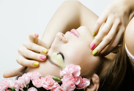 Beauty young woman with flowers and makeup close up, spa treatmentの写真素材