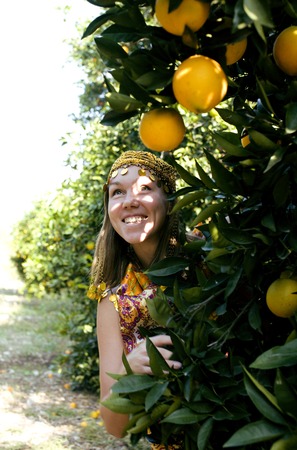 pretty islam woman in orange grove smilingの写真素材