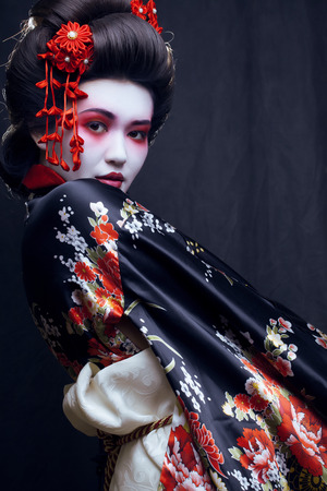 young pretty geisha in kimono with sakura and decorationの写真素材