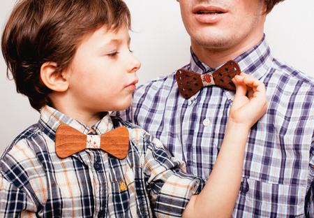 father with son in bowties on white background, casual look close upの写真素材