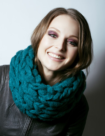 young pretty real woman in sweater and scarf all over her face smilingの写真素材