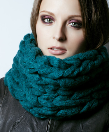 young pretty real woman in sweater and scarf all over her face smilingの写真素材