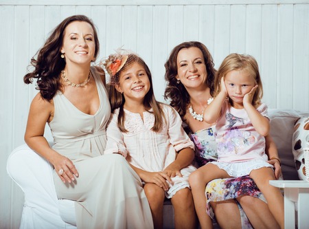 Mature sisters twins at home with little daughter, happy real familyの写真素材