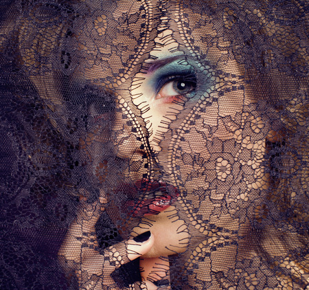 portrait of beauty young woman through lace close upの写真素材