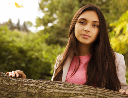 young pretty brunette girl in park smilingの写真素材