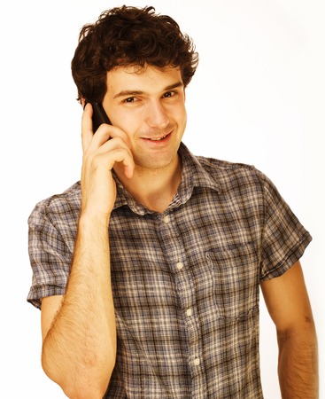 Portrait of handsome young man using cellphone isolated on white, cheerfull teenの写真素材