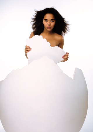 black skinned woman in big crashed egg isolatedの写真素材